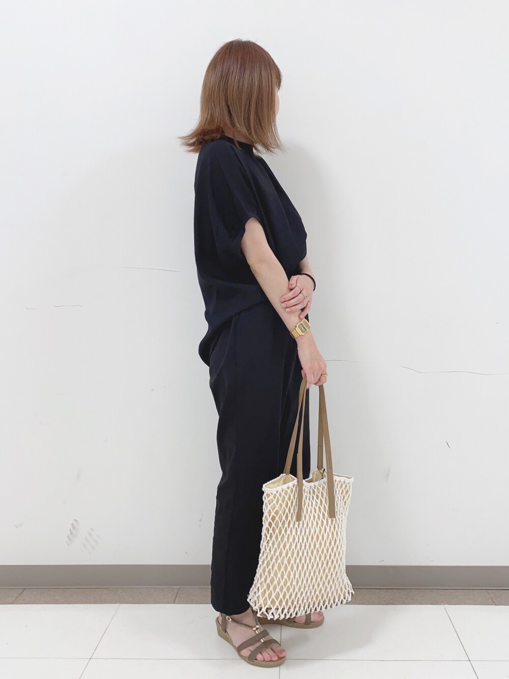 ブラック系のその他パンツ、ベージュ系のサンダル、ホワイト系のトートバッグを着用したレディースの春コーディネートの2枚目の写真