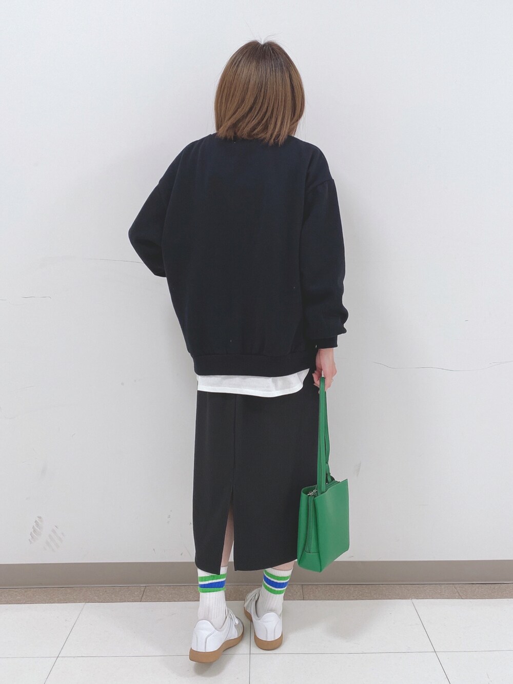 ブラック系のスウェット、ブラック系のスカート、ホワイト系のTシャツ/カットソーを着用したレディースの冬コーディネートの3枚目の写真