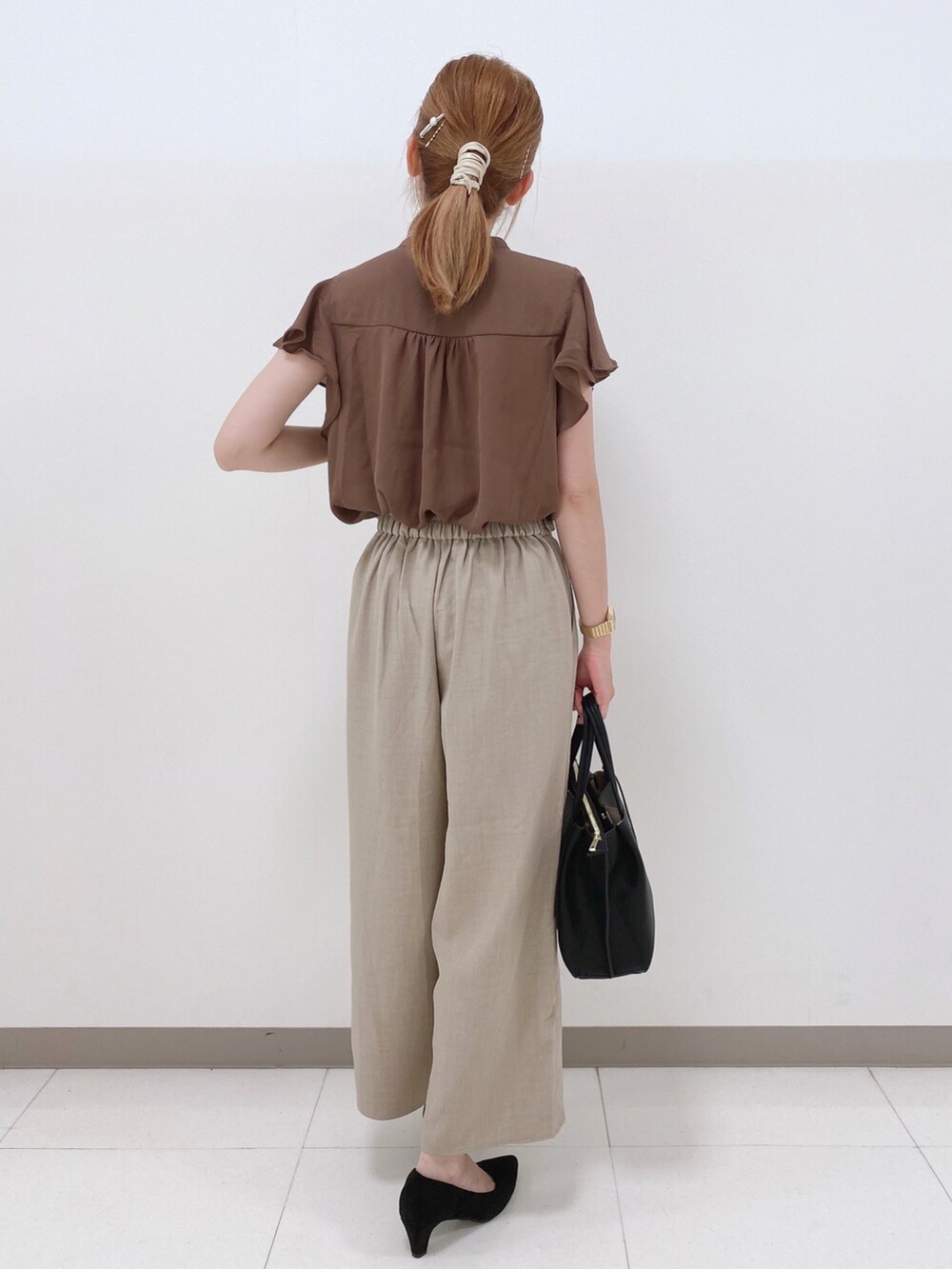ブラウン系のシャツ/ブラウス、ベージュ系のその他パンツ、ブラック系のパンプスを着用したレディースの夏コーディネートの3枚目の写真