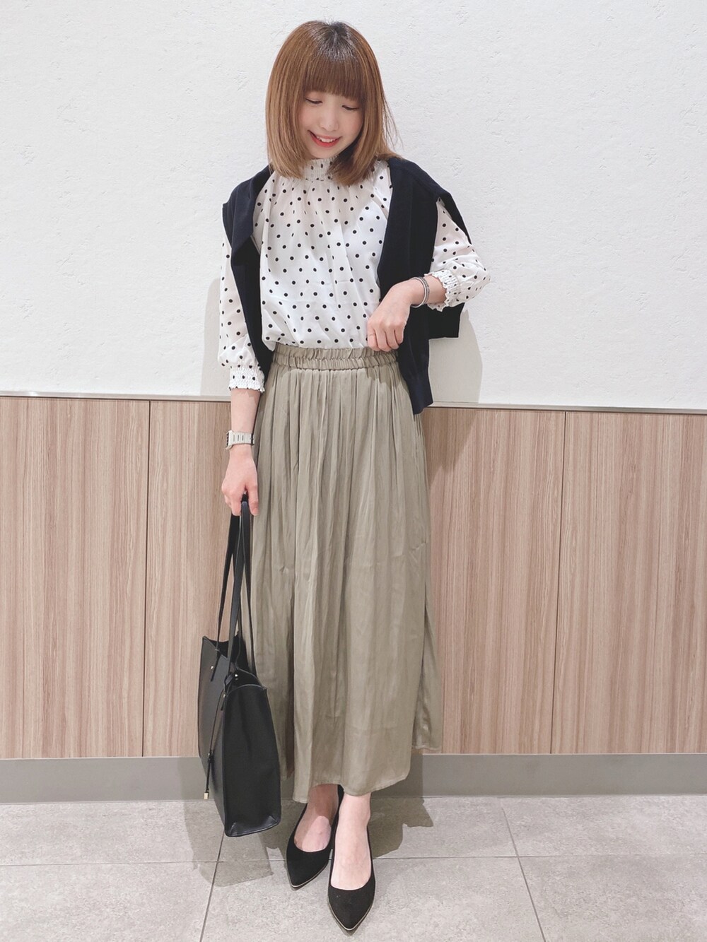ホワイト系のシャツ/ブラウス、ブラック系のカーディガン/ボレロ、グリーン系のスカートを着用したレディースの春コーディネートの4枚目の写真