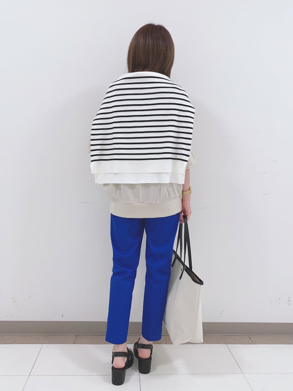 ベージュ系のシャツ/ブラウス、ブラック系のニット/セーター、ブルー系のその他パンツを着用したレディースの春コーディネートの3枚目の写真