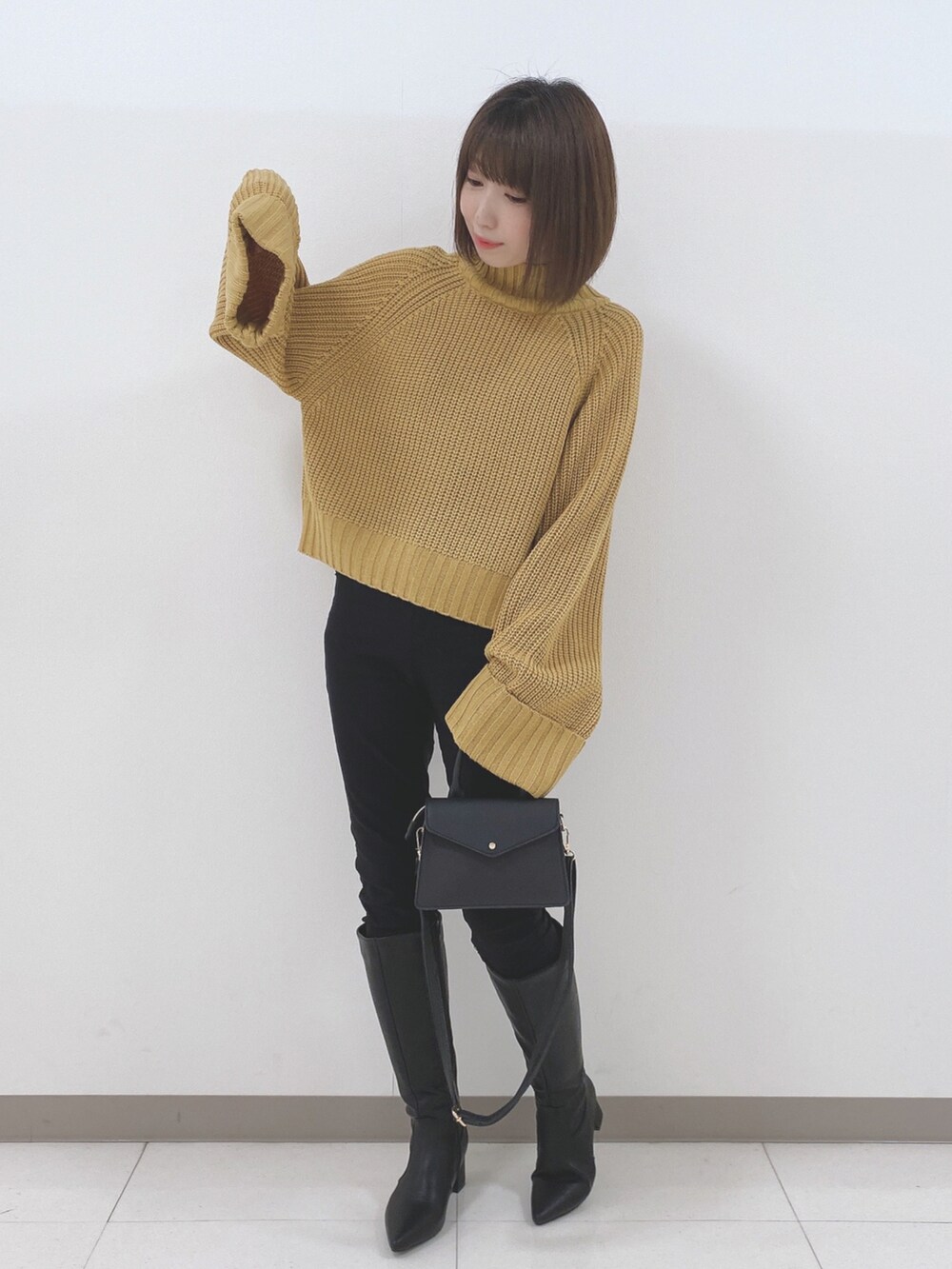 イエロー系のニット/セーター、ブラック系のその他パンツ、ブラック系のブーツを着用したレディースの冬コーディネートの4枚目の写真