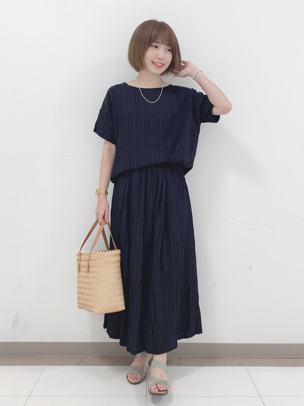 ブラック系のTシャツ/カットソー、ブラック系のスカート、ゴールド系のサンダルを着用したレディースの夏コーディネートの4枚目の写真