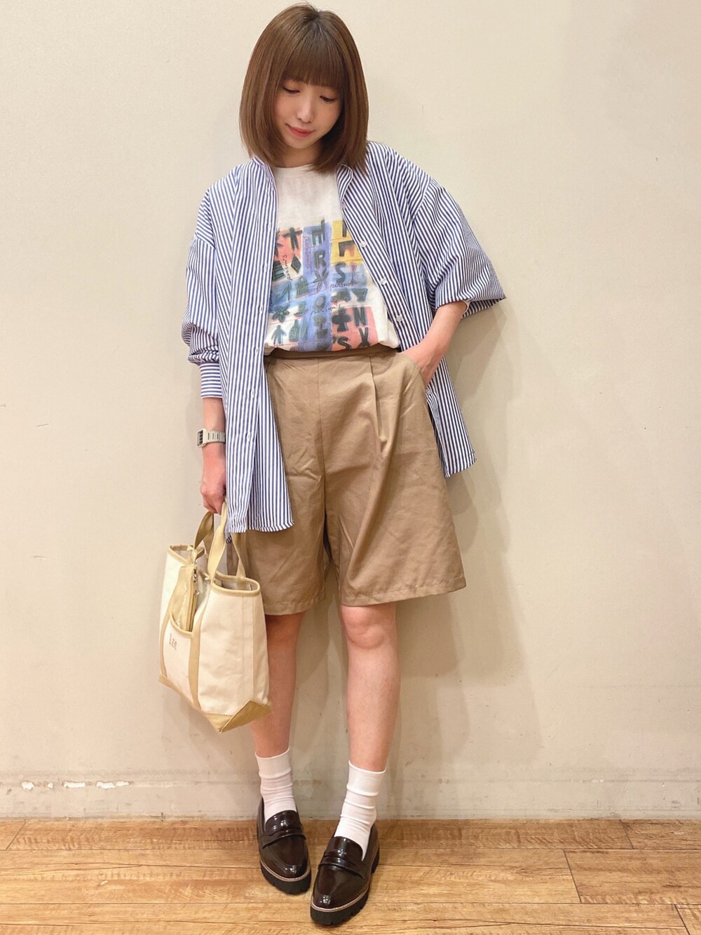 ブルー系のワンピース、ベージュ系のトートバッグ、ブラウン系のその他シューズを着用したレディースの春コーディネートの4枚目の写真