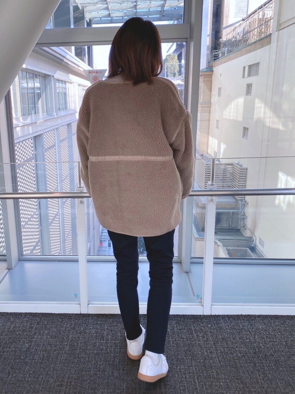 ベージュ系のノーカラージャケット、ベージュ系のニット/セーター、ホワイト系のTシャツ/カットソーを着用したレディースの冬コーディネートの2枚目の写真