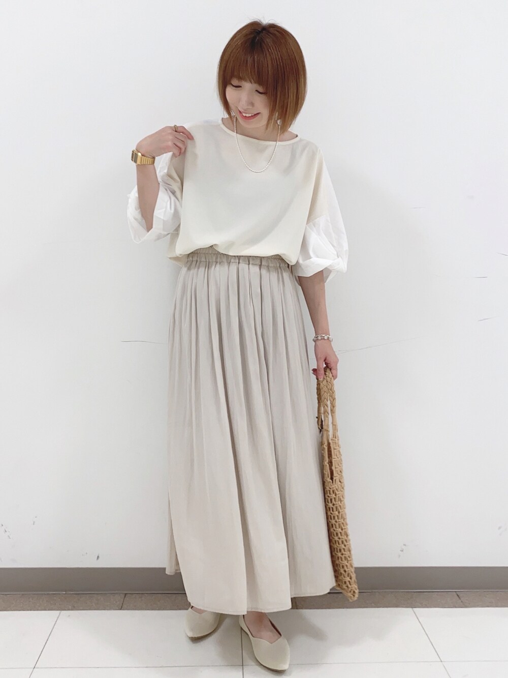 ベージュ系のTシャツ/カットソー、ベージュ系のパンプス、ブラウン系のトートバッグを着用したレディースの夏コーディネートの4枚目の写真