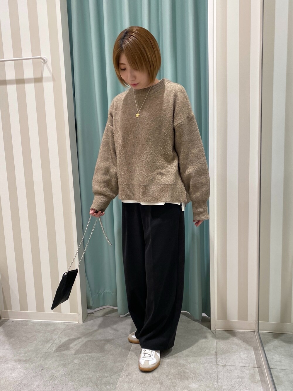 ベージュ系のテーラードジャケット、イエロー系のニット/セーター、ブラック系のその他パンツを着用したレディースの秋コーディネートの4枚目の写真