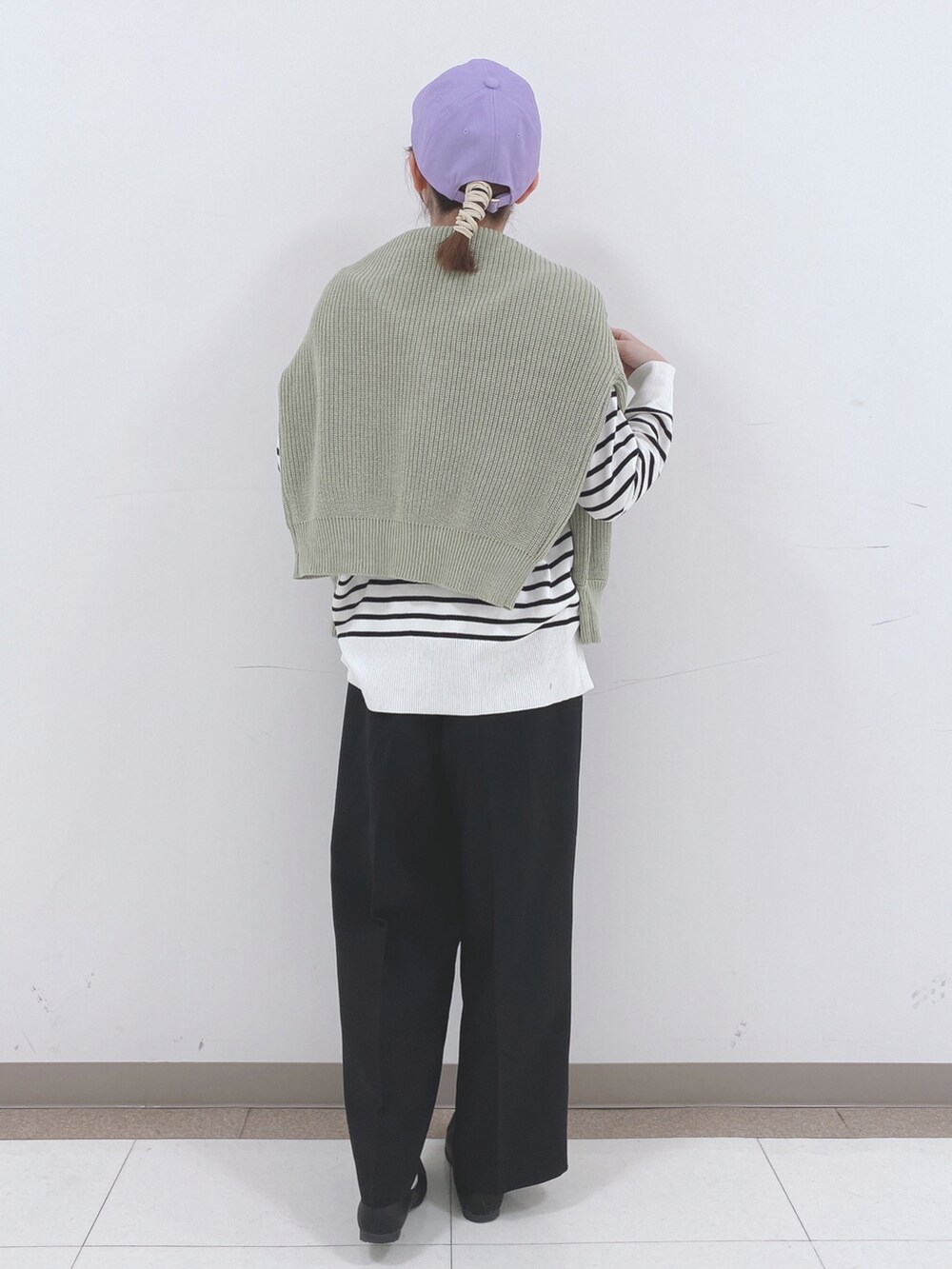 ブラック系のニット/セーター、グリーン系のカーディガン/ボレロ、ブラック系のその他パンツを着用したレディースの春コーディネートの3枚目の写真