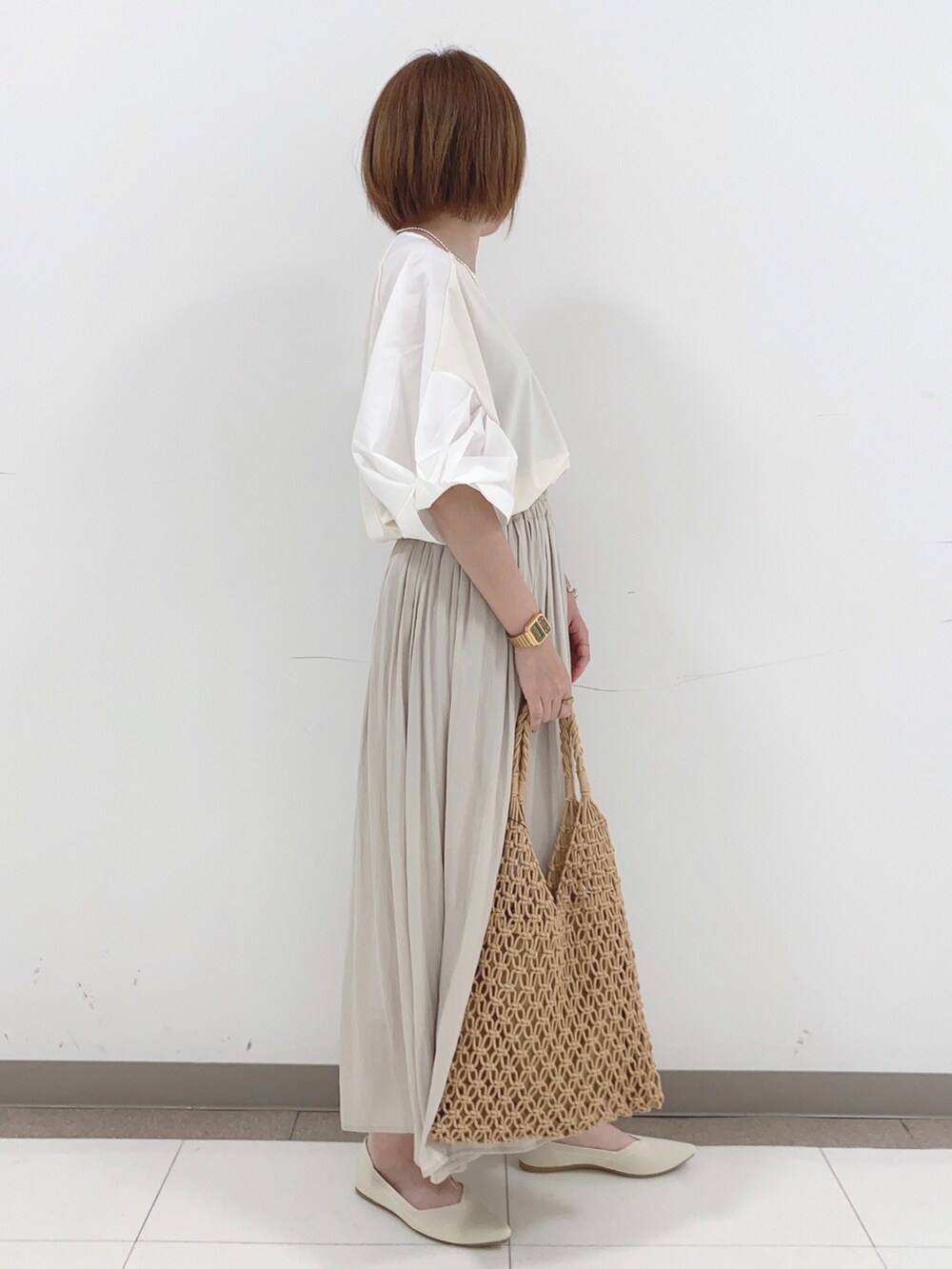 ベージュ系のTシャツ/カットソー、ベージュ系のパンプス、ブラウン系のトートバッグを着用したレディースの夏コーディネートの2枚目の写真