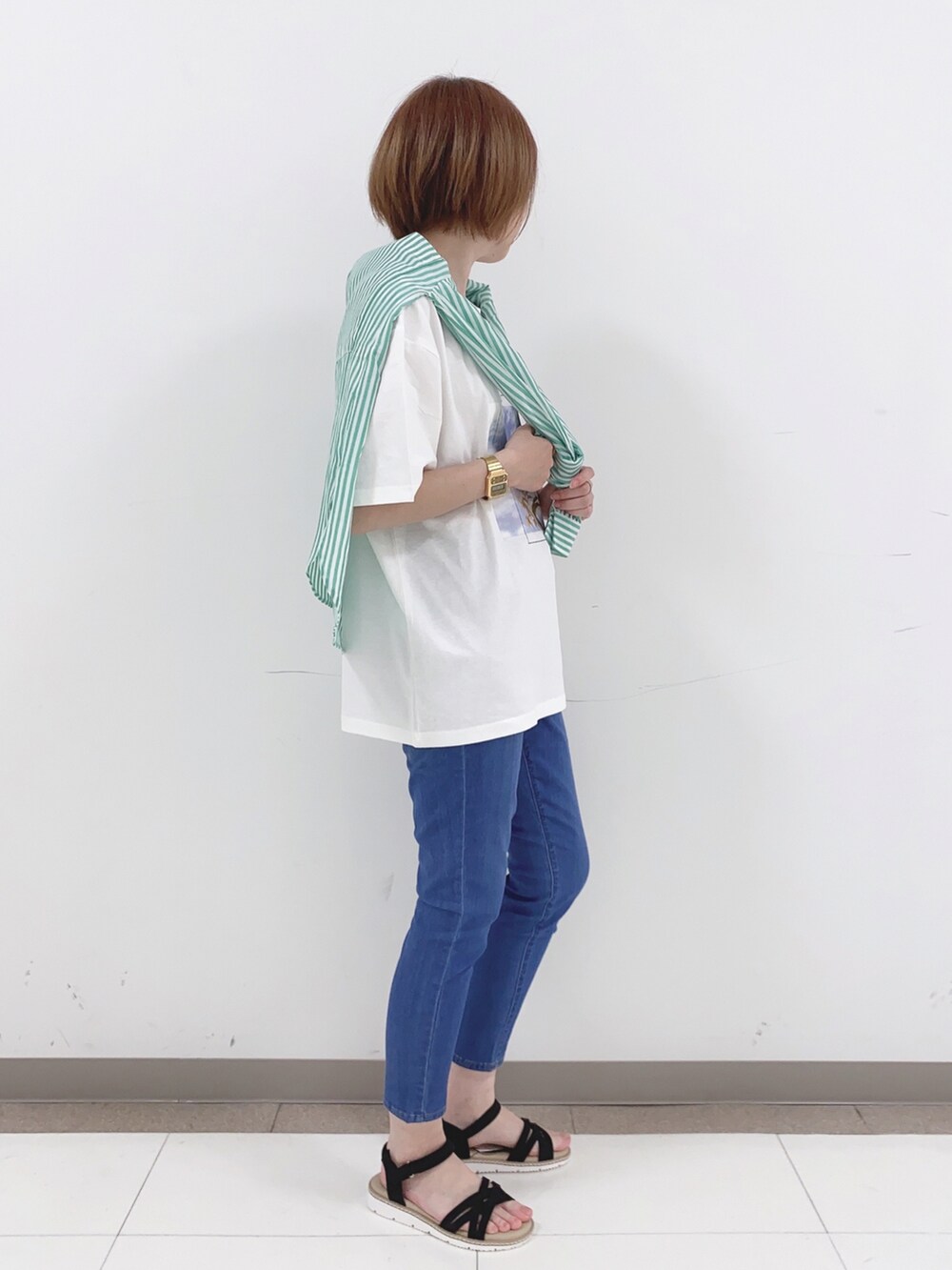 グリーン系のシャツ/ブラウス、ホワイト系のTシャツ/カットソー、ブルー系のデニムパンツを着用したレディースの春コーディネートの2枚目の写真