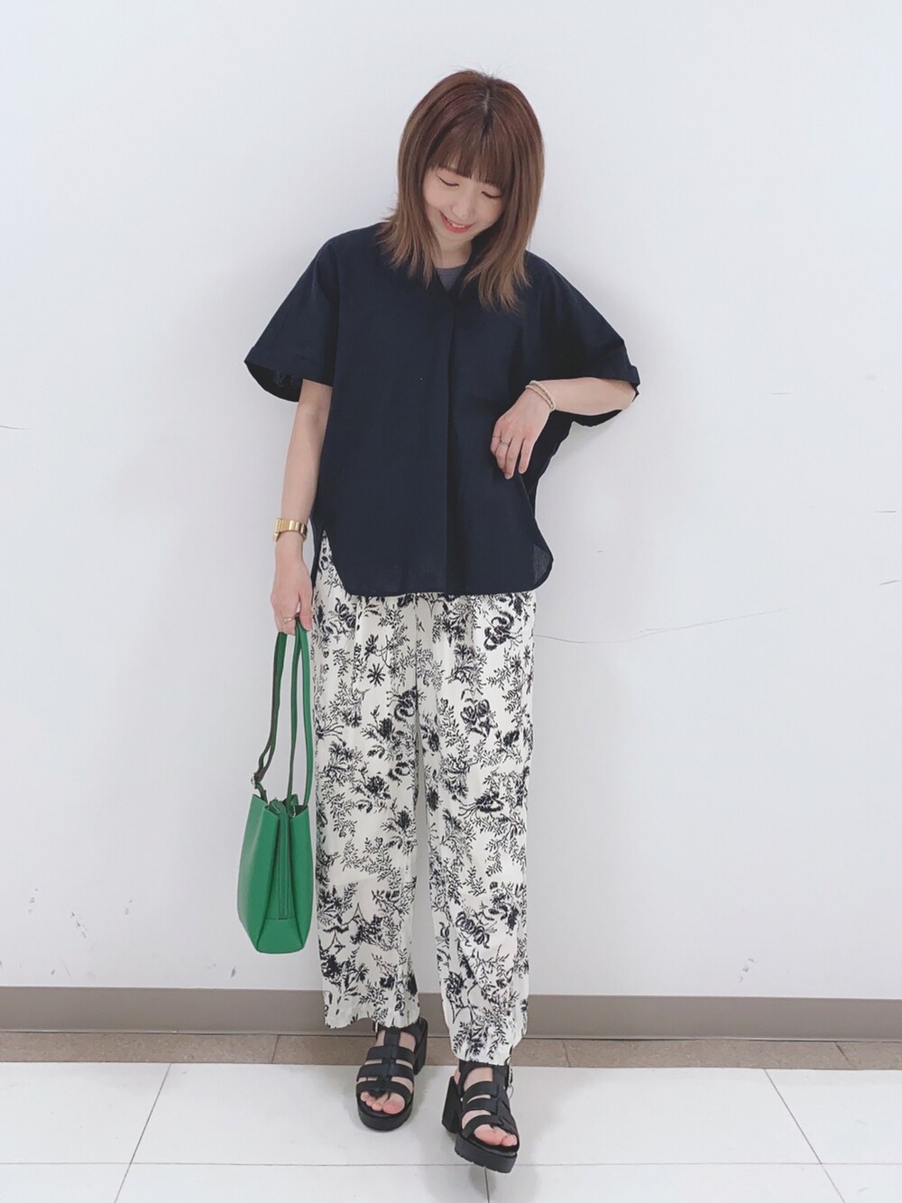 ベージュ系のその他パンツ、ブラック系のサンダル、グリーン系のショルダーバッグを着用したレディースの春コーディネートの4枚目の写真