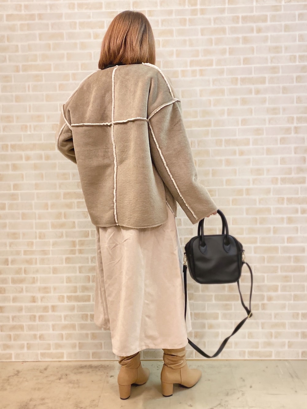 ブラック系のTシャツ/カットソー、ブラウン系のブルゾン、ブラック系のショルダーバッグを着用したレディースの冬コーディネートの3枚目の写真