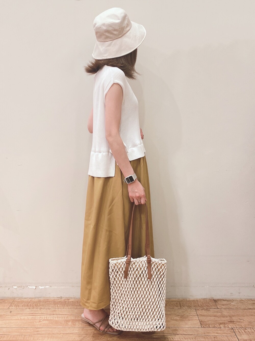 イエロー系のワンピース、ホワイト系のトートバッグ、ベージュ系のサンダルを着用したレディースの春コーディネートの2枚目の写真