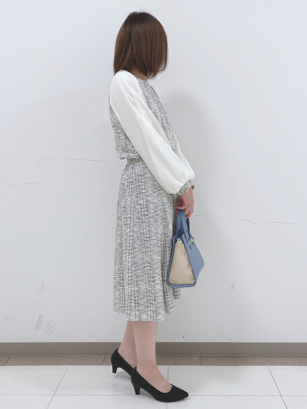 ホワイト系のスカート、ホワイト系のTシャツ/カットソー、ブラック系のパンプスを着用したレディースの冬コーディネートの2枚目の写真