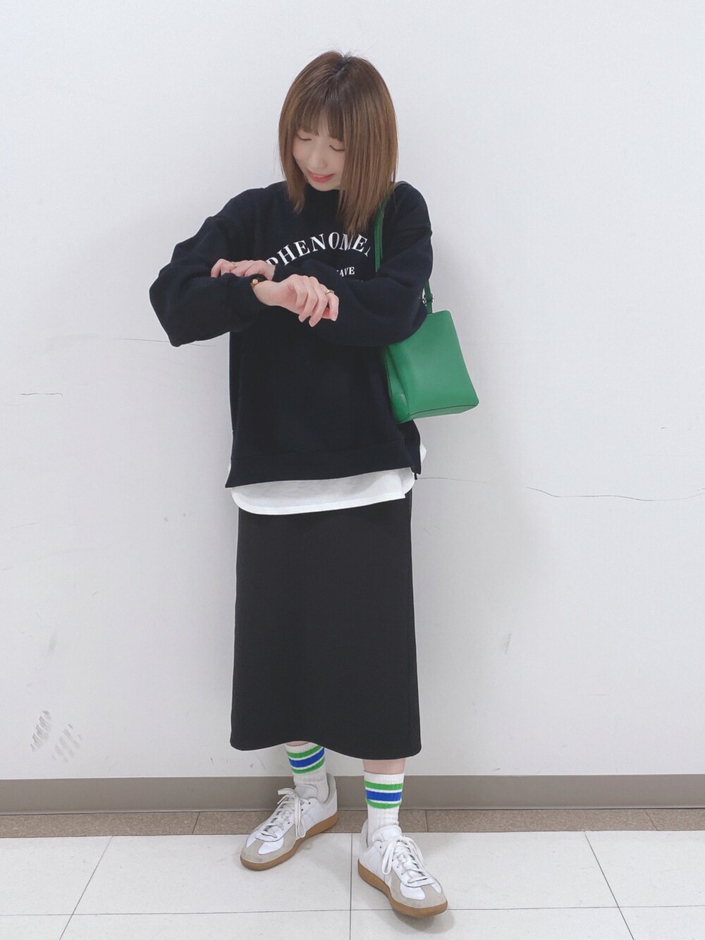 ブラック系のスウェット、ブラック系のスカート、ホワイト系のTシャツ/カットソーを着用したレディースの冬コーディネートの4枚目の写真