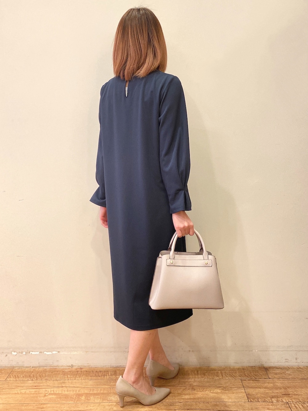 ブルー系のワンピース、グレー系のショルダーバッグ、グレー系のパンプスを着用したレディースの冬コーディネートの3枚目の写真