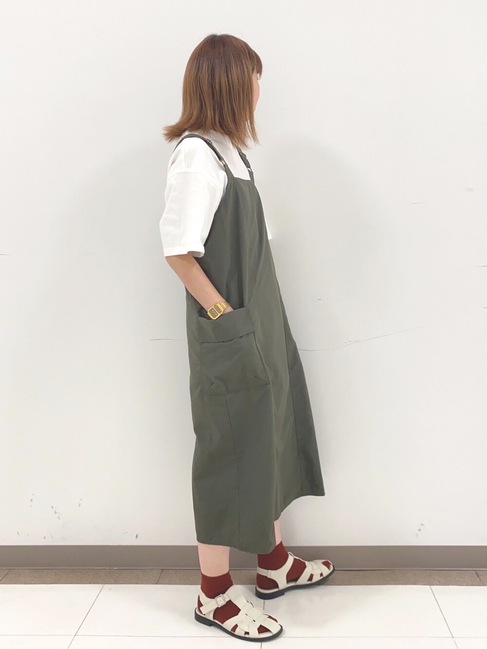 ホワイト系のTシャツ/カットソー、グリーン系のスカートを着用したレディースの春コーディネートの2枚目の写真