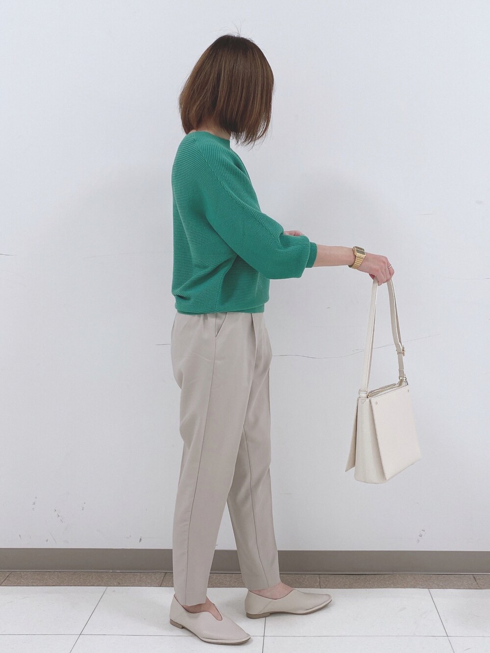 グリーン系のニット/セーター、ベージュ系のその他パンツ、ホワイト系のパンプスを着用したレディースの冬コーディネートの2枚目の写真