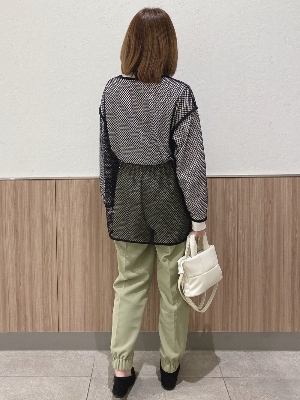 グリーン系のその他パンツ、ブラック系のその他トップス、ホワイト系のショルダーバッグを着用したレディースの春コーディネートの3枚目の写真