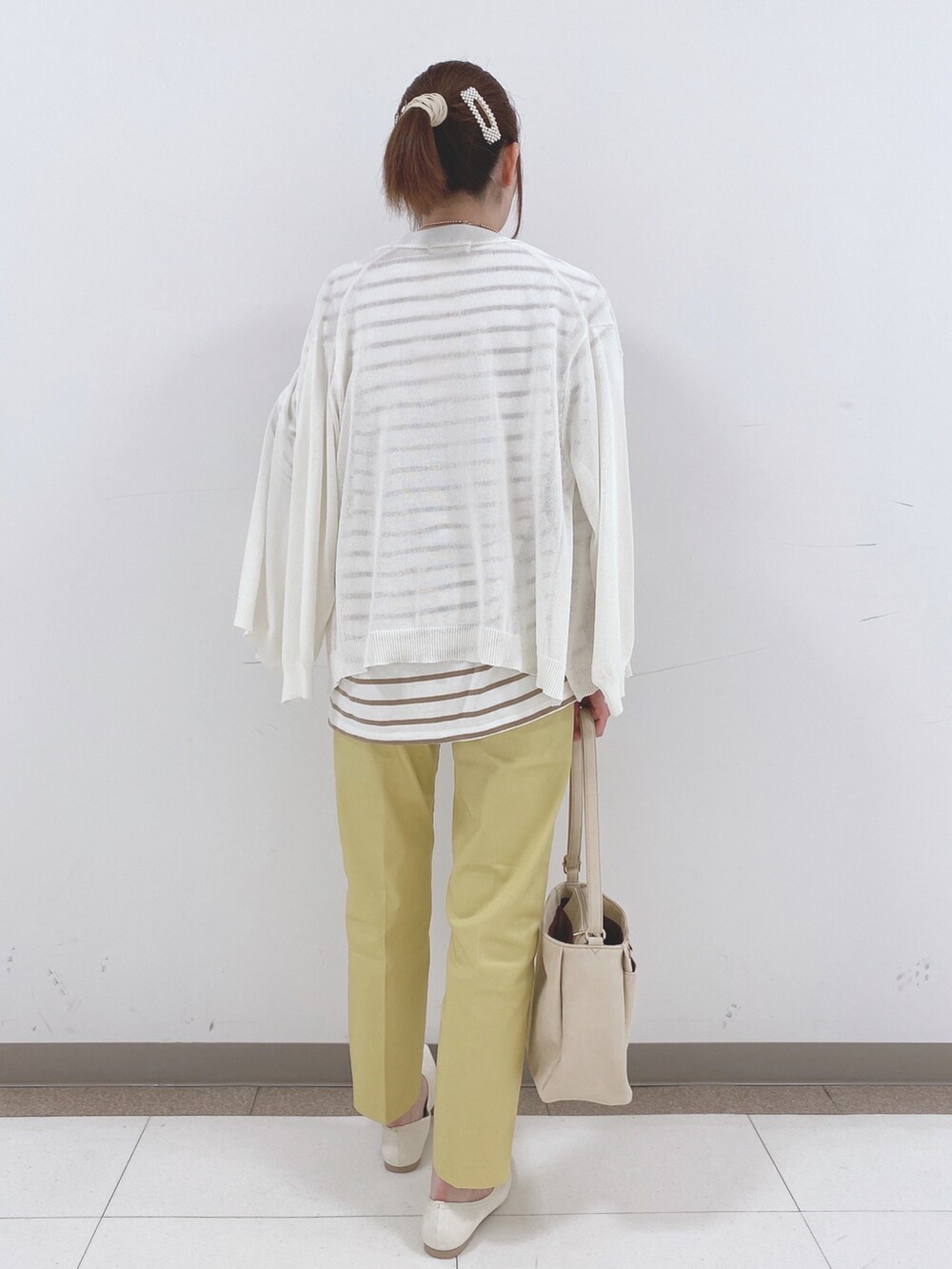 ベージュ系のTシャツ/カットソー、ホワイト系のカーディガン/ボレロ、イエロー系のその他パンツを着用したレディースの春コーディネートの3枚目の写真