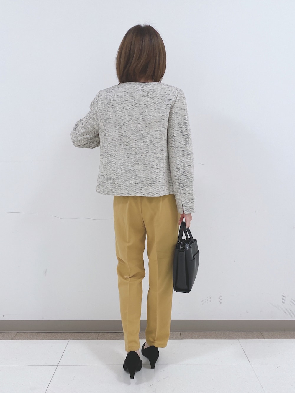 グレー系のノーカラージャケット、イエロー系のシャツ/ブラウス、イエロー系のその他パンツを着用したレディースの冬コーディネートの3枚目の写真