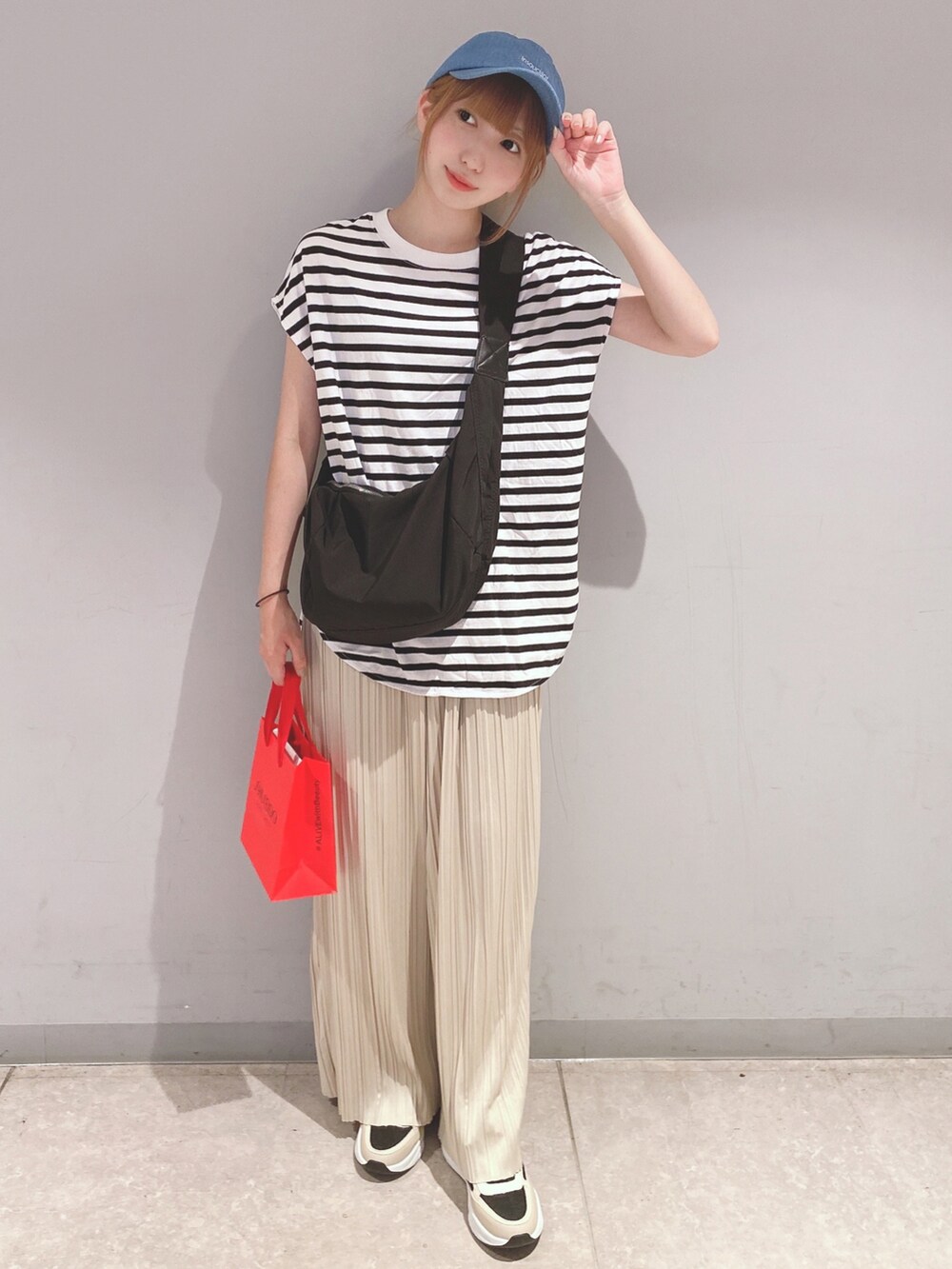 ブラック系のTシャツ/カットソー、ホワイト系のパンツ、ベージュ系のスニーカーを着用したレディースの夏コーディネートの2枚目の写真