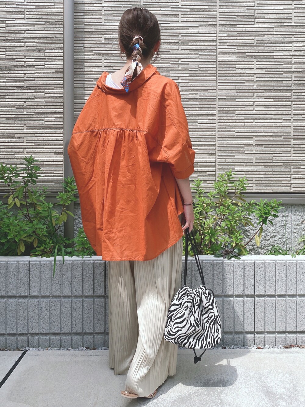 ホワイト系のタンクトップ、オレンジ系のシャツ/ブラウス、ブラック系のショルダーバッグを着用したレディースの夏コーディネートの2枚目の写真