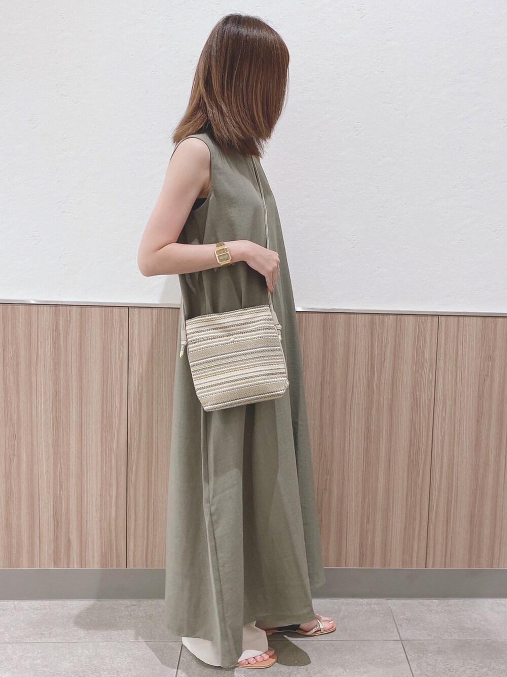 ブラック系のサンダル、グリーン系のワンピース、ベージュ系のその他パンツを着用したレディースの夏コーディネートの2枚目の写真