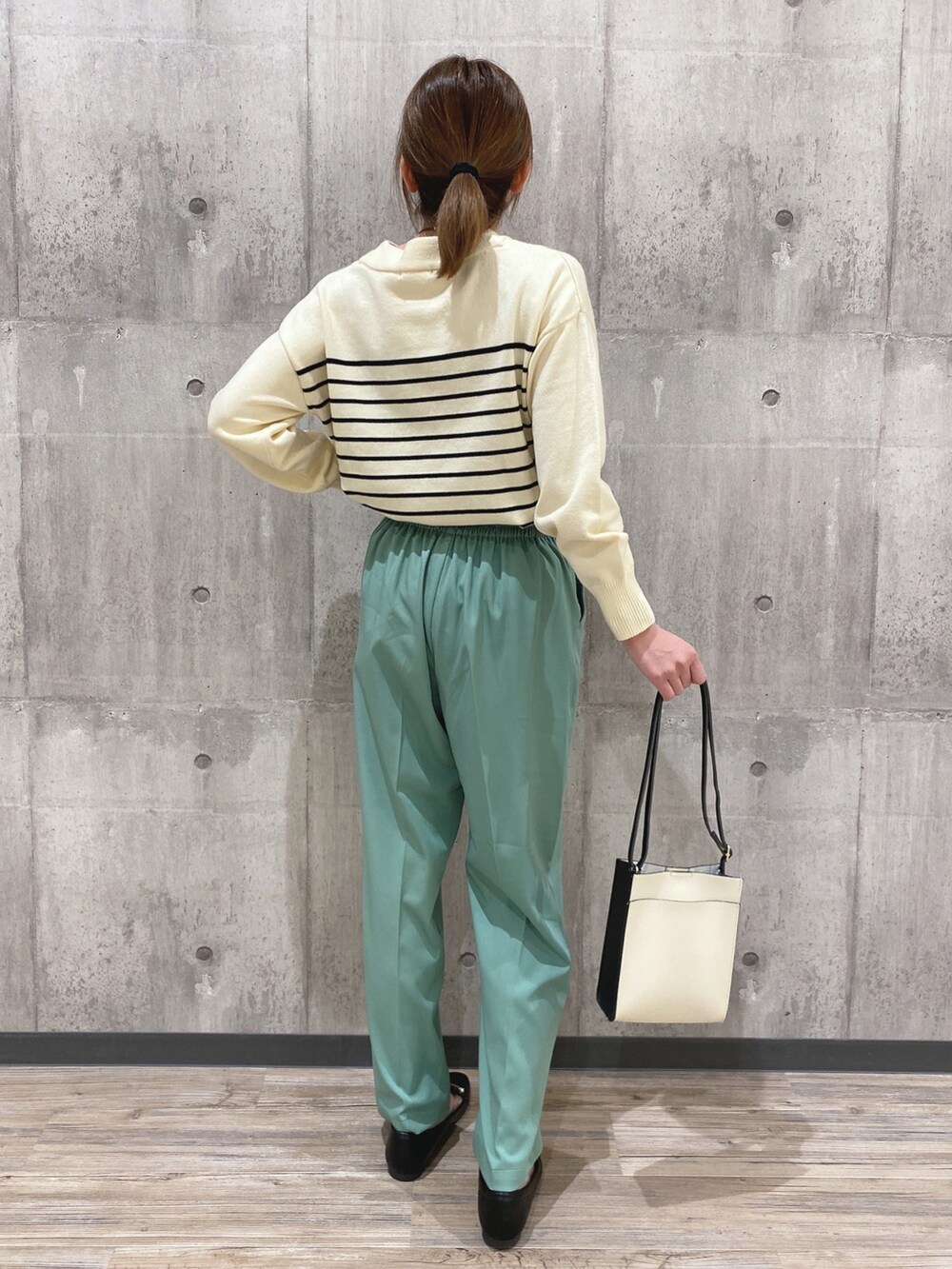 ホワイト系のニット/セーター、グリーン系のその他パンツ、ブラック系のショルダーバッグを着用したレディースの冬コーディネートの2枚目の写真