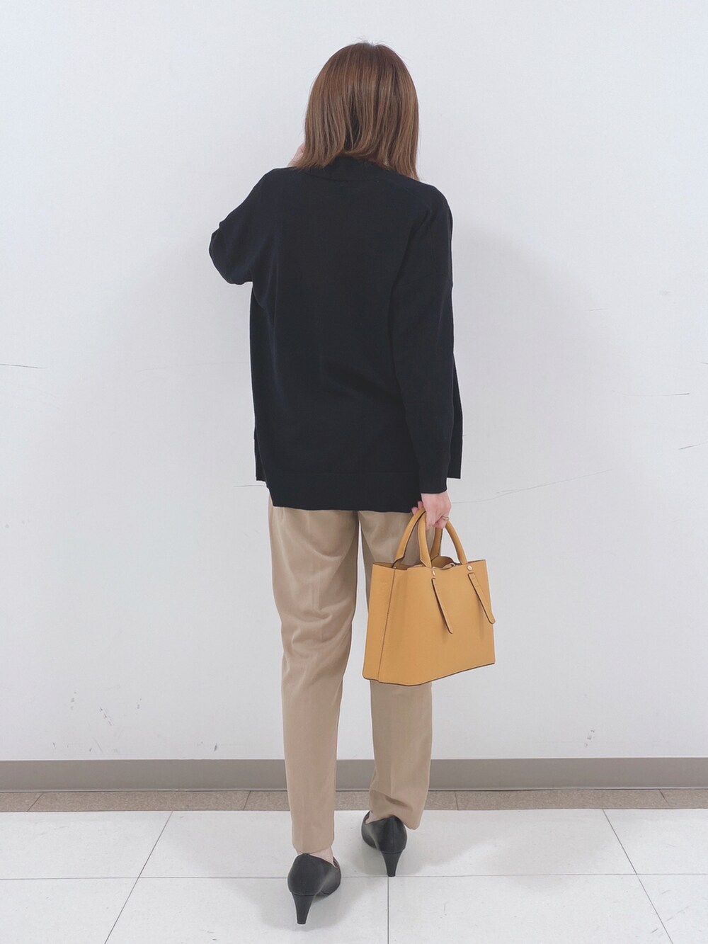 ホワイト系のシャツ/ブラウス、ブラック系のカーディガン/ボレロ、ベージュ系のその他パンツを着用したレディースの春コーディネートの3枚目の写真