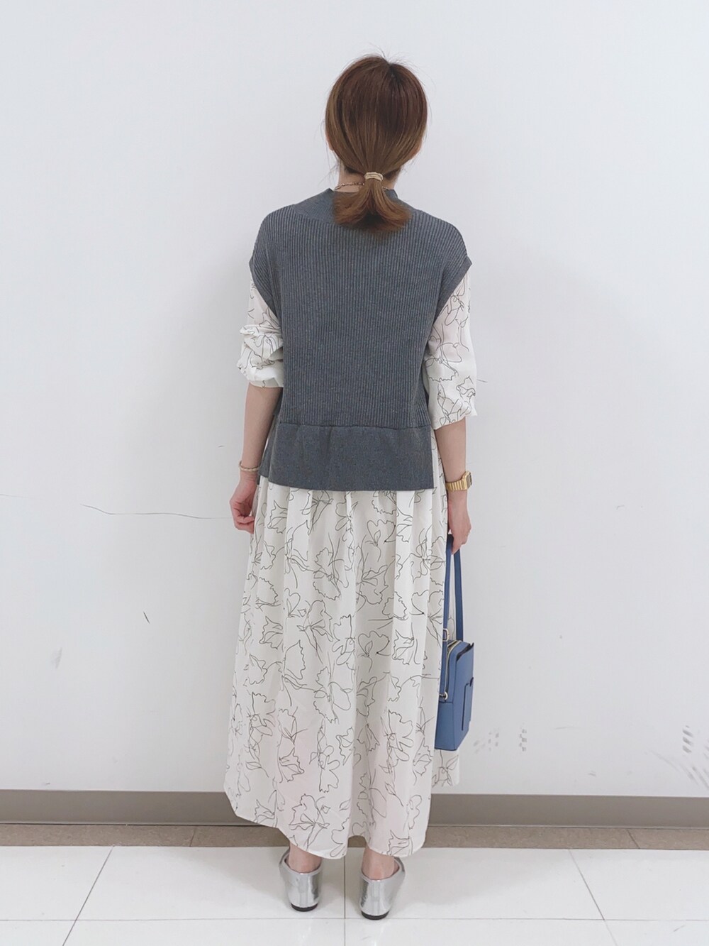 グレー系のワンピース、ブルー系のショルダーバッグを着用したレディースの春コーディネートの3枚目の写真