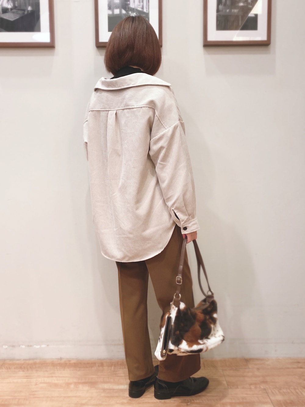 ベージュ系のミリタリージャケット、ブラック系のニット/セーター、イエロー系のその他パンツを着用したレディースの秋コーディネートの2枚目の写真