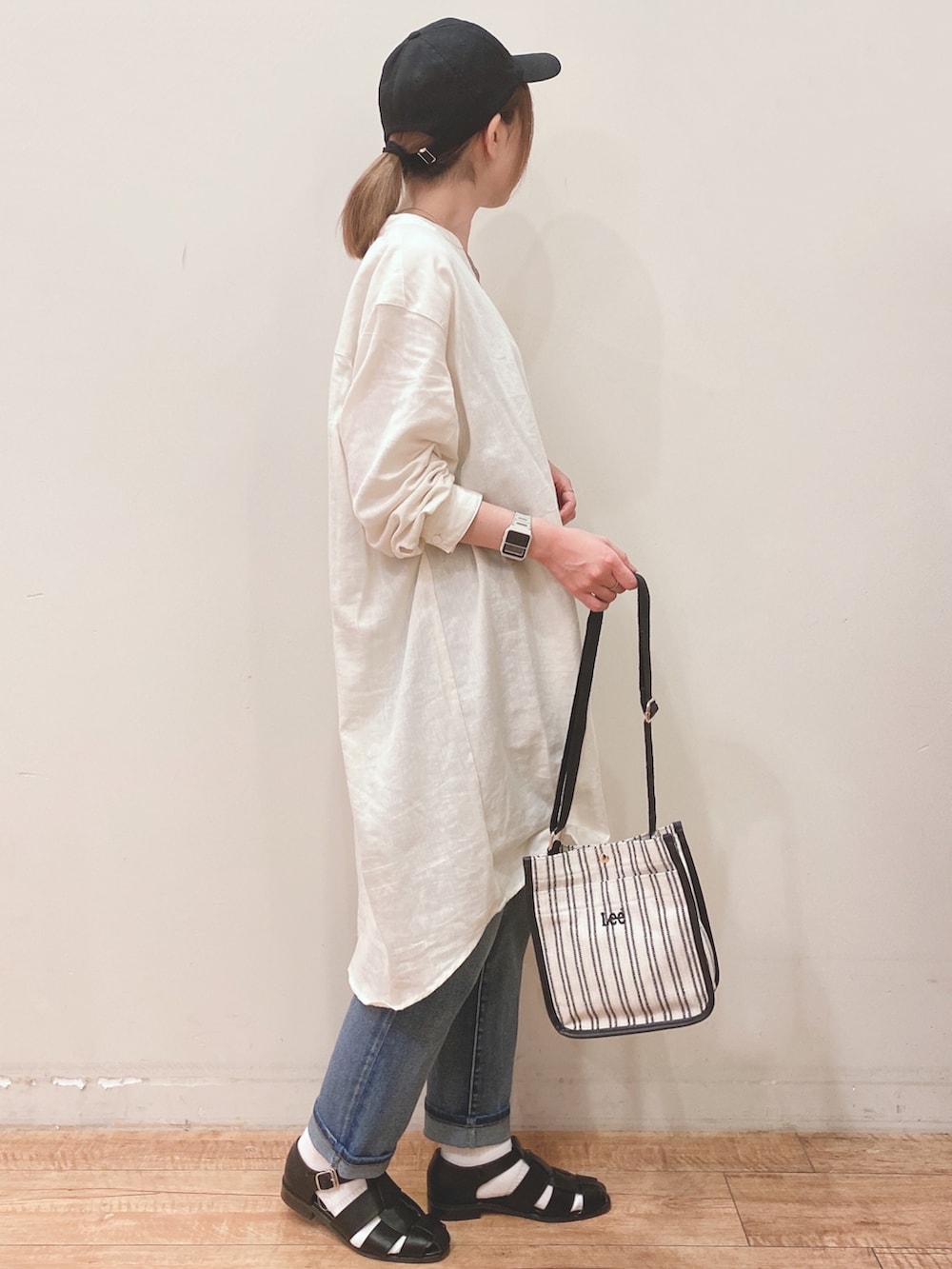 ブラウン系のタンクトップ、ホワイト系のワンピース、ブルー系のデニムパンツを着用したレディースの春コーディネートの2枚目の写真