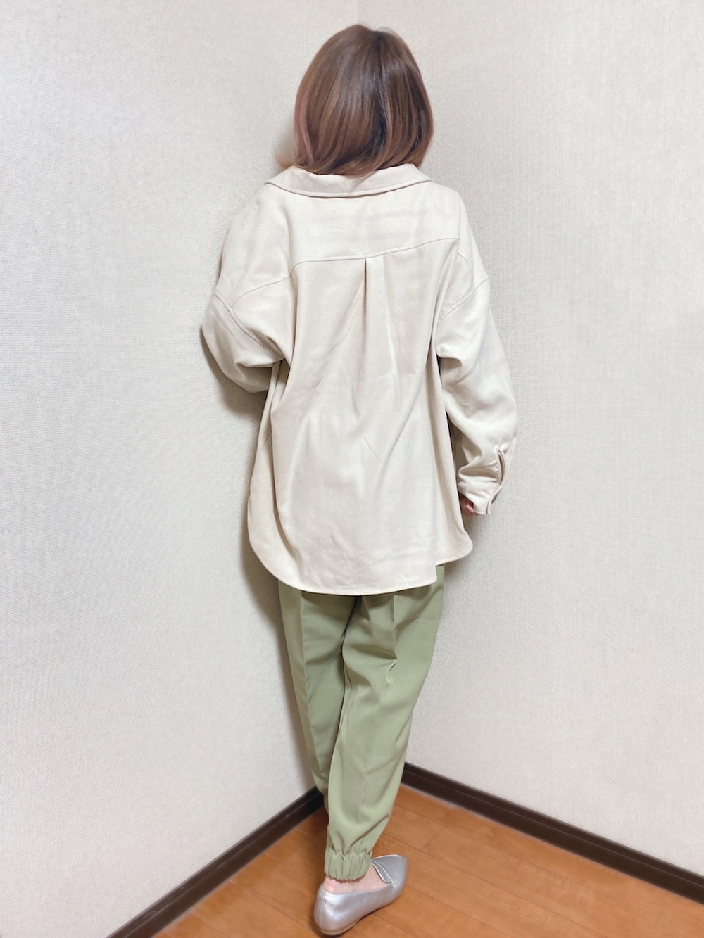 グリーン系のその他パンツ、ブラック系のニット/セーター、ホワイト系のミリタリージャケットを着用したレディースの冬コーディネートの3枚目の写真