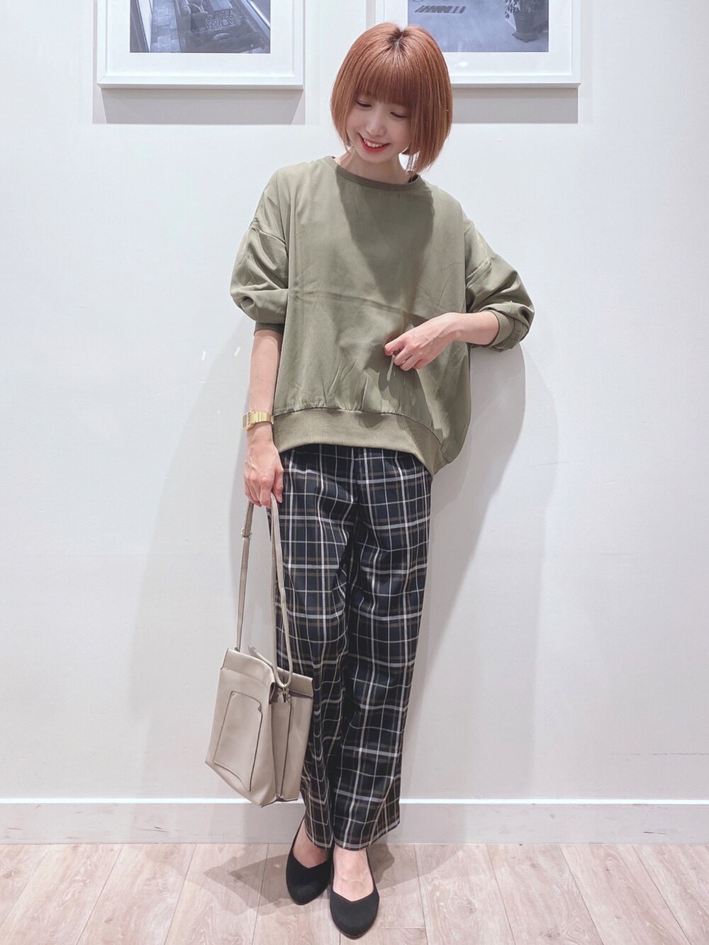 グリーン系のシャツ/ブラウス、ブラック系のパンツ、グレー系のショルダーバッグを着用したレディースの秋コーディネートの4枚目の写真