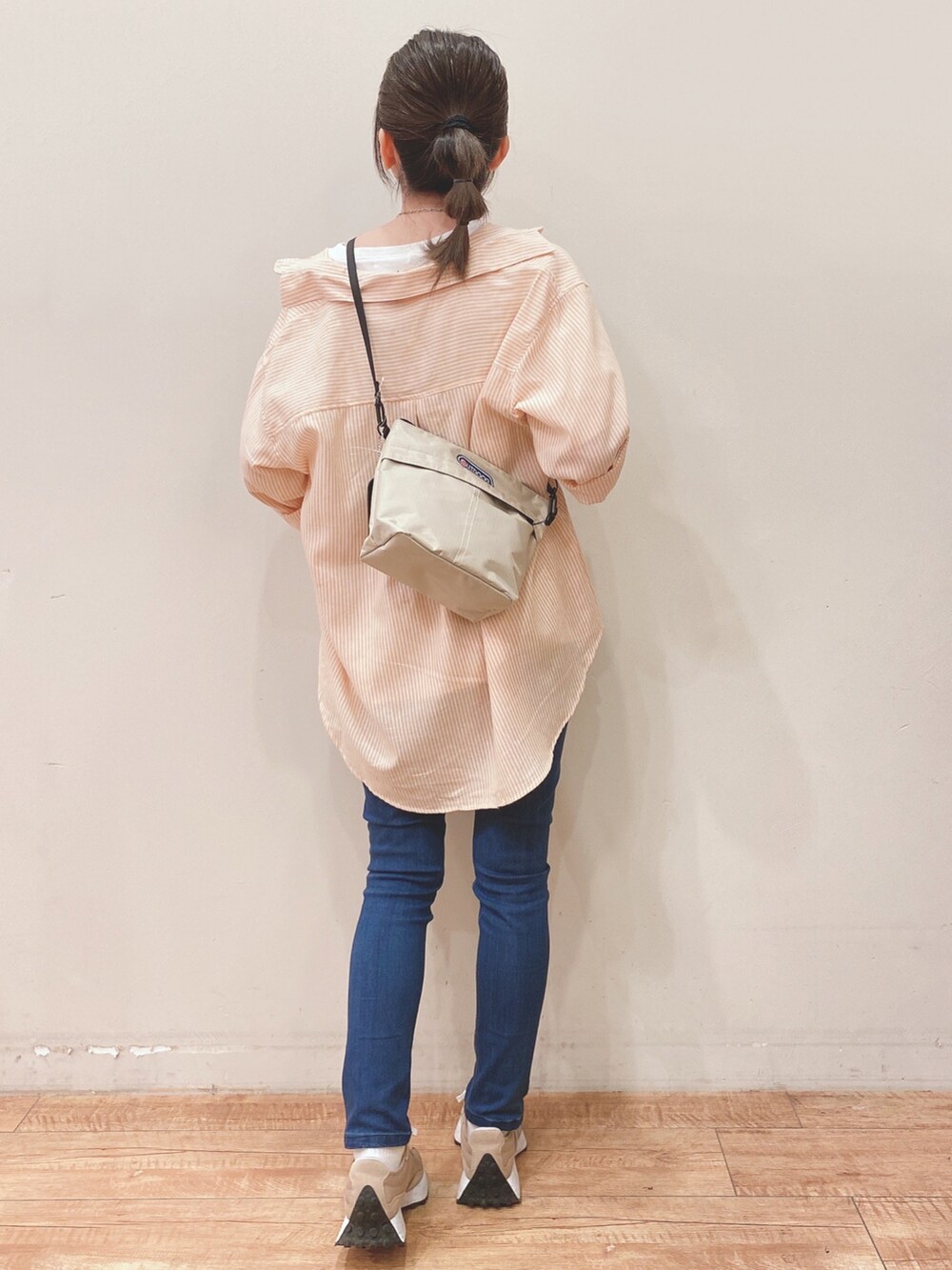 ホワイト系のTシャツ/カットソー、オレンジ系のシャツ/ブラウス、ベージュ系のショルダーバッグを着用したレディースの春コーディネートの3枚目の写真