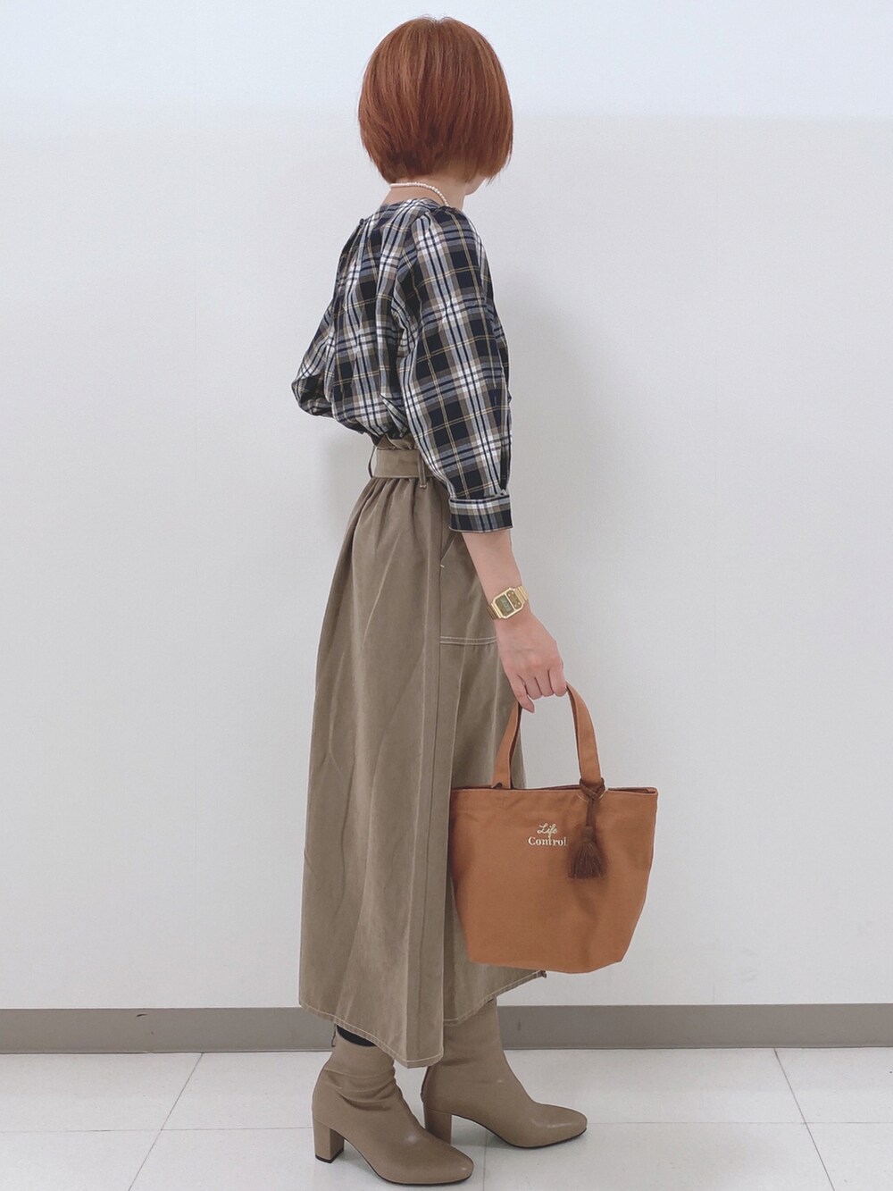 ブルー系のシャツ/ブラウス、ベージュ系のスカート、ベージュ系のブーツを着用したレディースの秋コーディネートの2枚目の写真