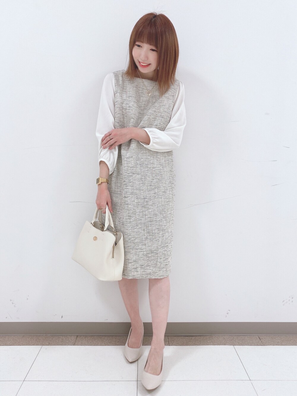 グレー系のワンピース、ベージュ系のパンプス、ホワイト系のトートバッグを着用したレディースの春コーディネートの4枚目の写真