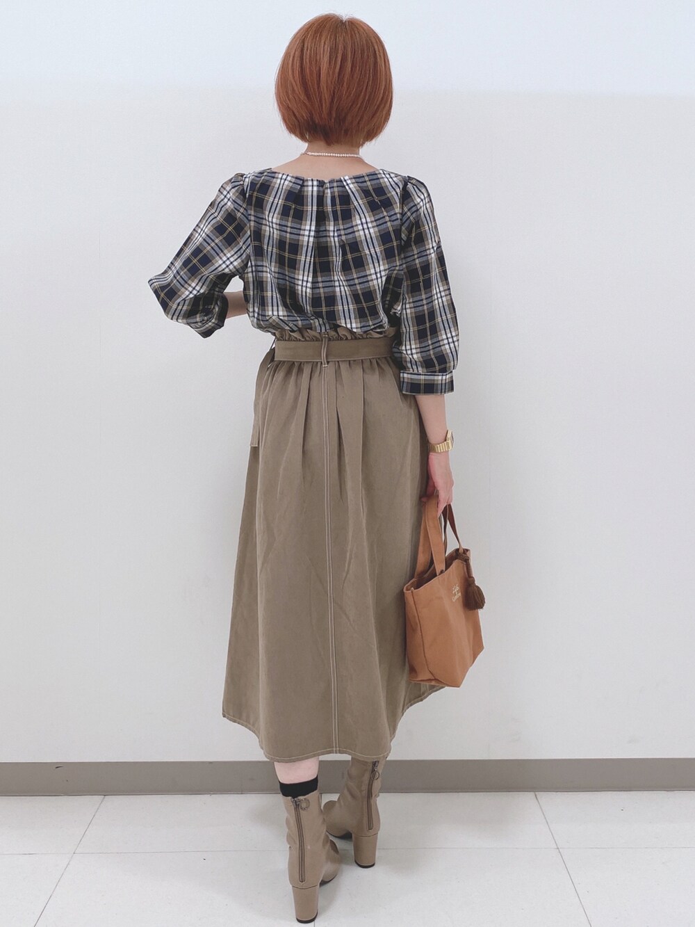 ブルー系のシャツ/ブラウス、ベージュ系のスカート、ベージュ系のブーツを着用したレディースの秋コーディネートの3枚目の写真