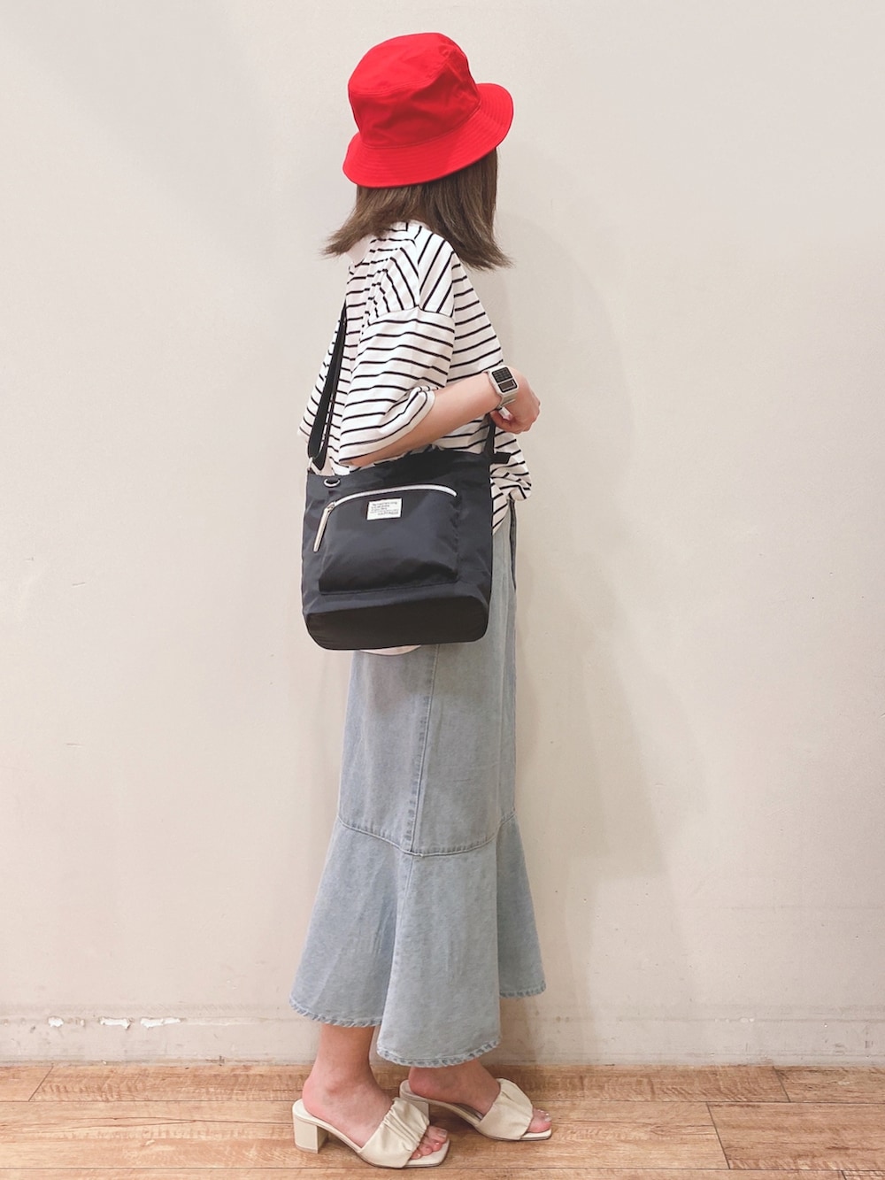 ブラック系のTシャツ/カットソー、ブルー系のスカート、ホワイト系のサンダルを着用したレディースの春コーディネートの2枚目の写真