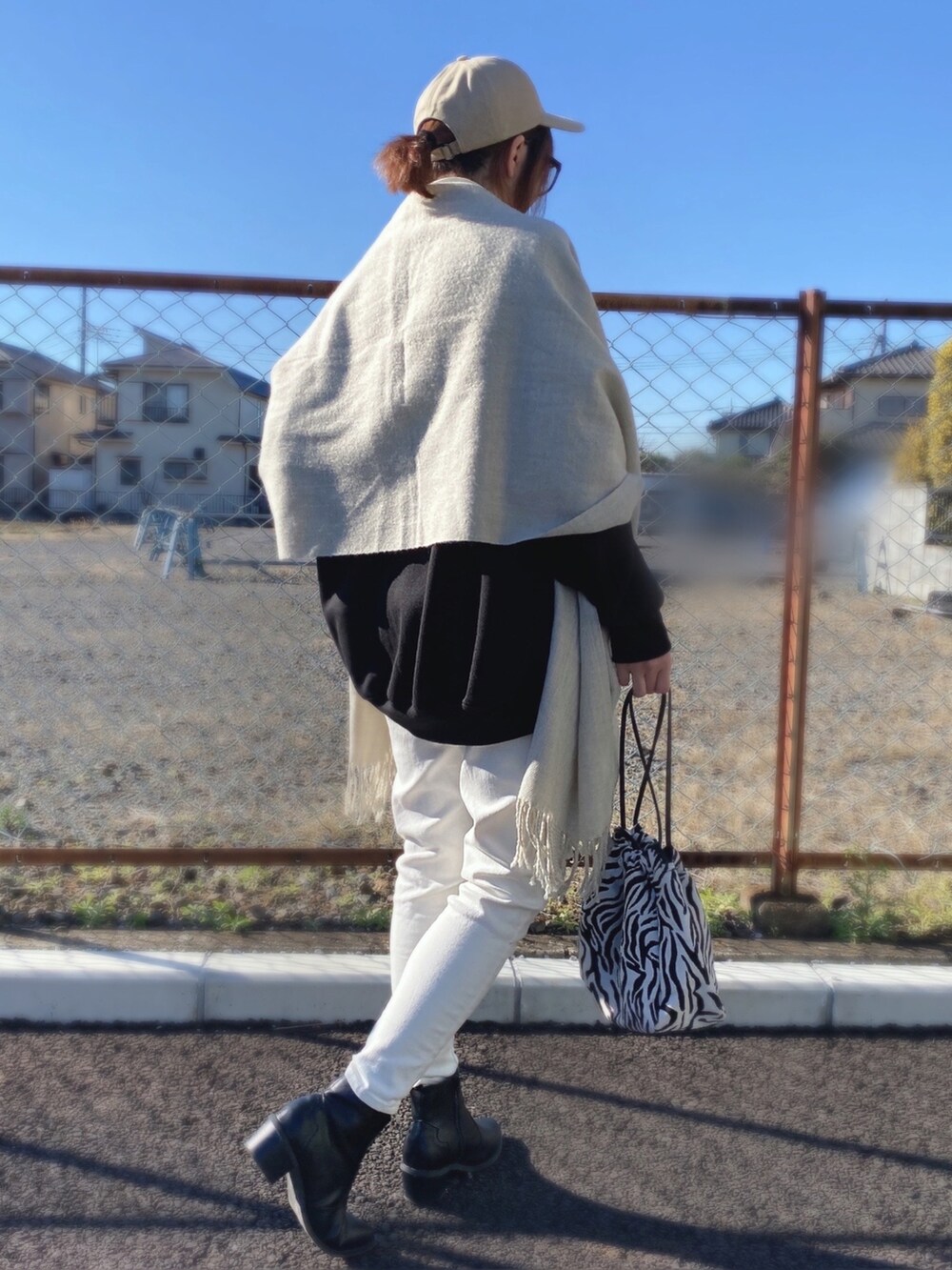 ブラック系のスウェット、ホワイト系のTシャツ/カットソー、ホワイト系のデニムパンツを着用したレディースの冬コーディネートの2枚目の写真