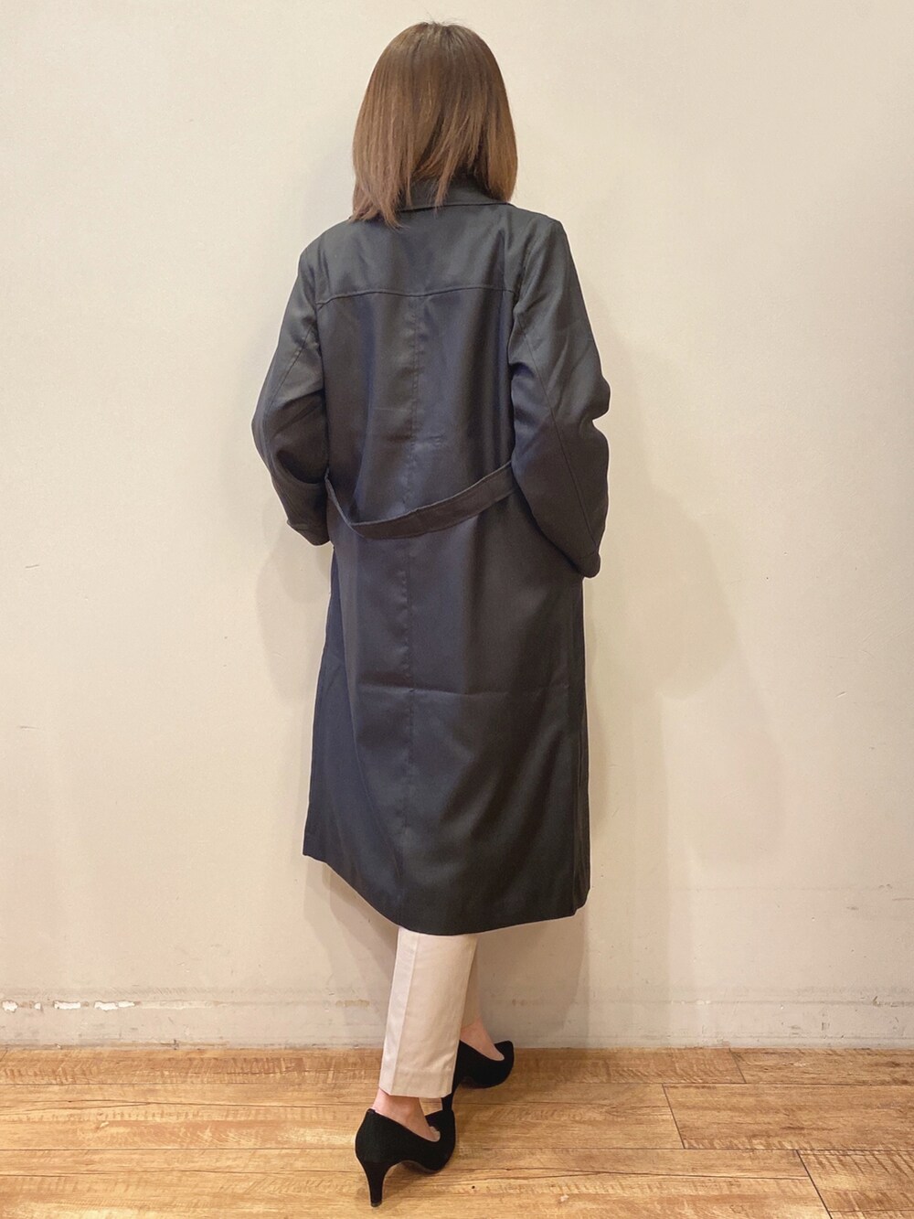ブラック系のTシャツ/カットソー、ブラック系のトレンチコート、ベージュ系のパンツを着用したレディースの春コーディネートの3枚目の写真