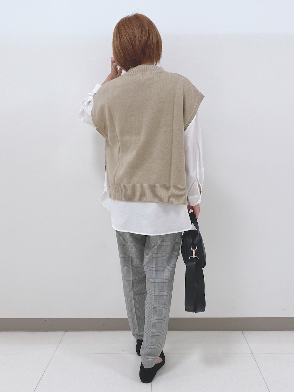 ベージュ系のベスト、ホワイト系のシャツ/ブラウス、ブラック系のパンプスを着用したレディースの秋コーディネートの3枚目の写真