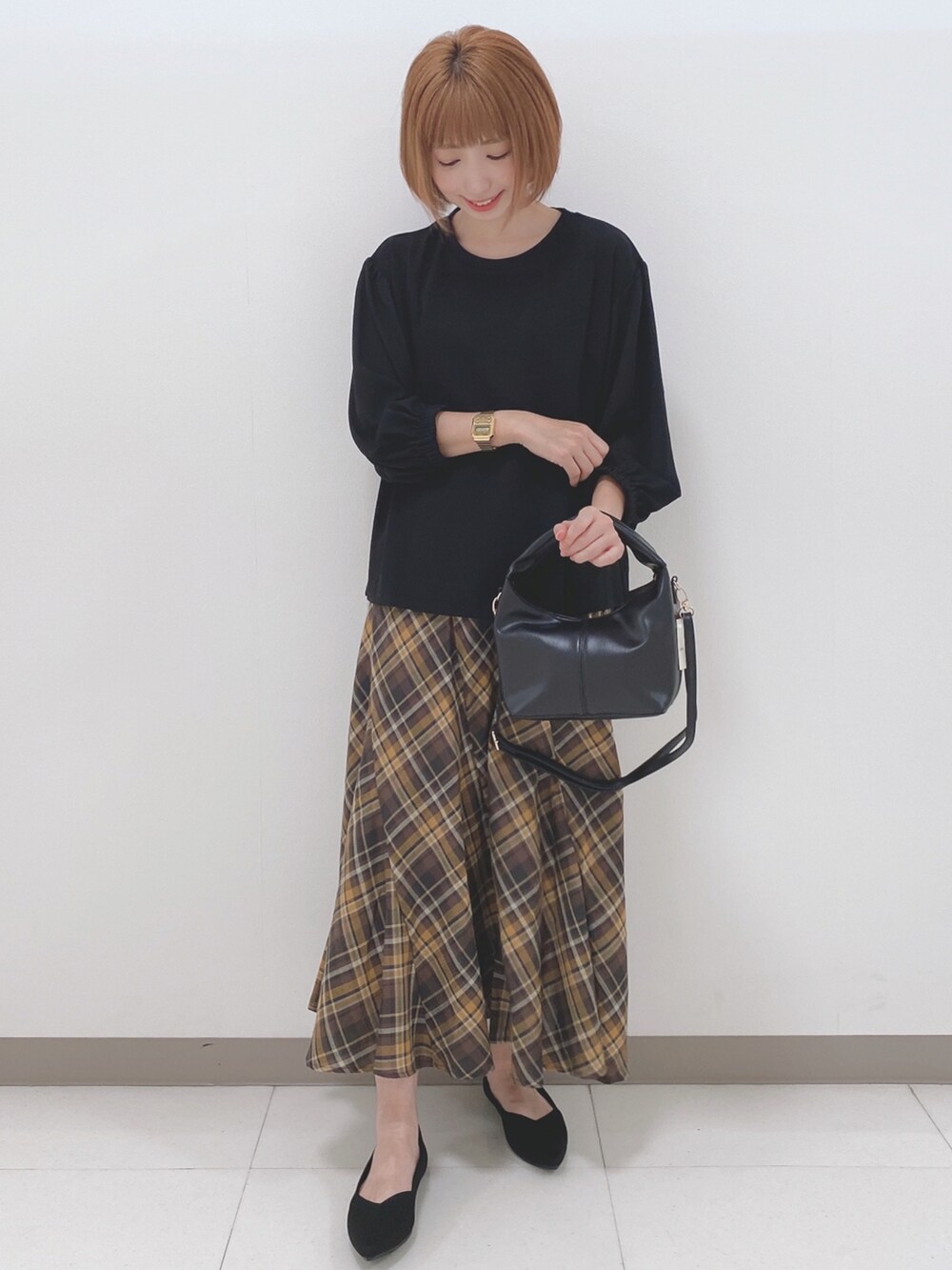 ブラック系のパンプス、ブラック系のトートバッグ、ブラック系のTシャツ/カットソーを着用したレディースの秋コーディネートの4枚目の写真