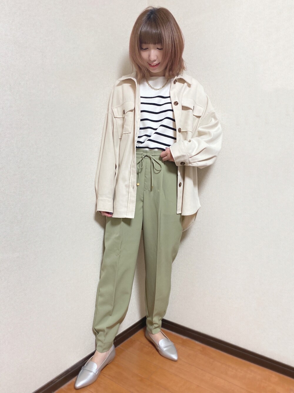 グリーン系のその他パンツ、ブラック系のニット/セーター、ホワイト系のミリタリージャケットを着用したレディースの冬コーディネートの2枚目の写真