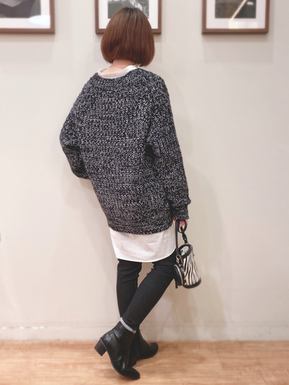 ブラック系のカーディガン/ボレロ、ブラック系のショルダーバッグ、ブラック系のデニムパンツを着用したレディースの秋コーディネートの2枚目の写真