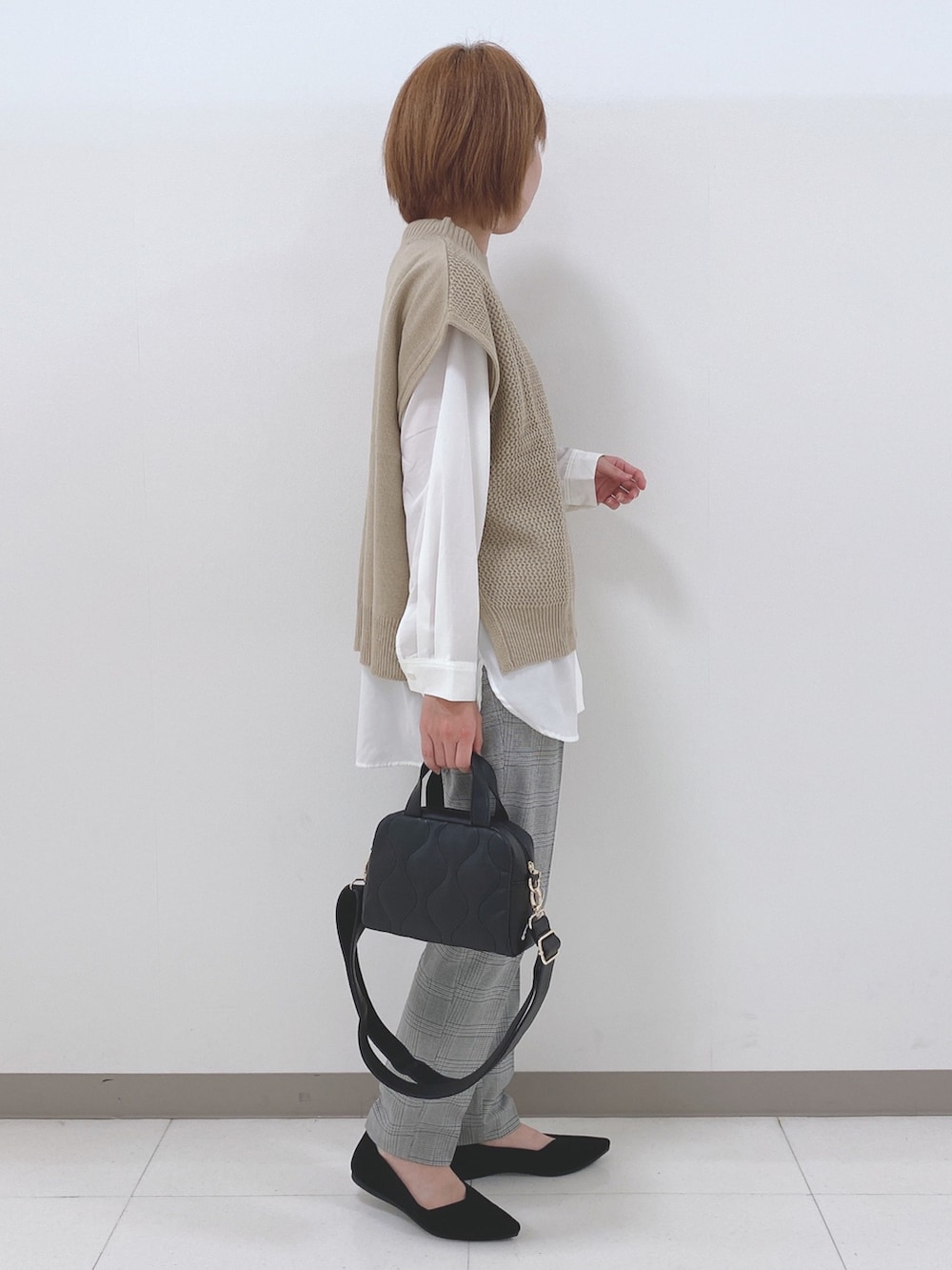 ベージュ系のベスト、ホワイト系のシャツ/ブラウス、ブラック系のパンプスを着用したレディースの秋コーディネートの2枚目の写真