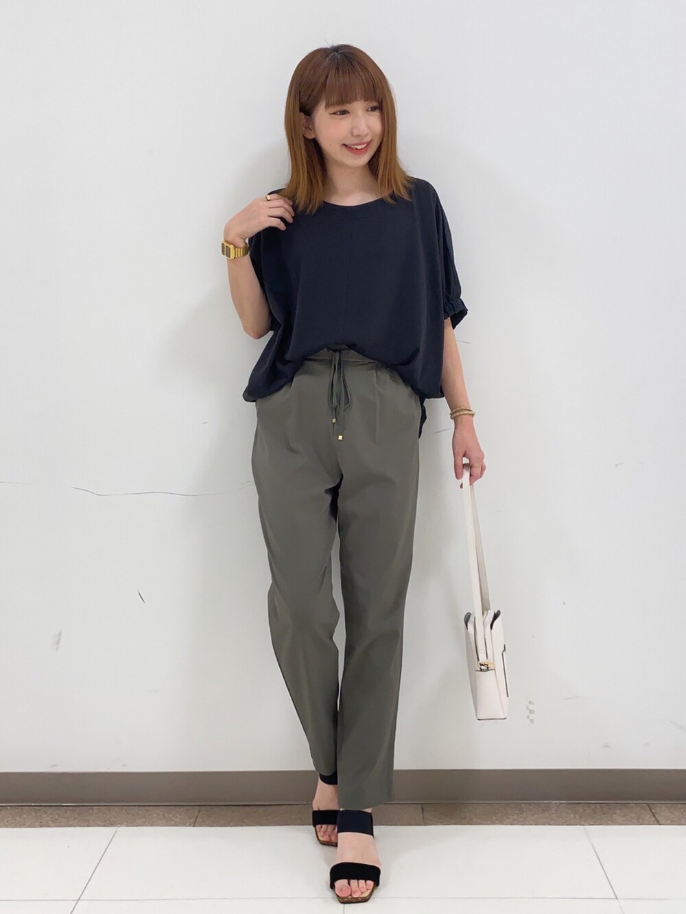 ブラック系のTシャツ/カットソー、グリーン系のその他パンツ、ホワイト系のショルダーバッグを着用したレディースの春コーディネートの4枚目の写真