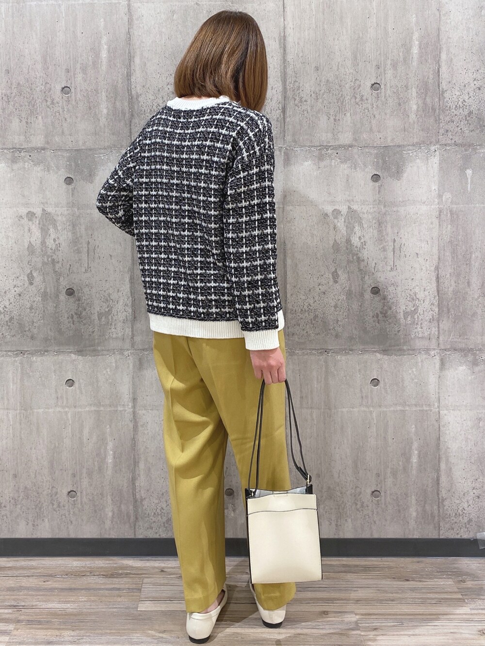 ブラック系のカーディガン/ボレロ、イエロー系のその他パンツ、ブラック系のショルダーバッグを着用したレディースの冬コーディネートの2枚目の写真