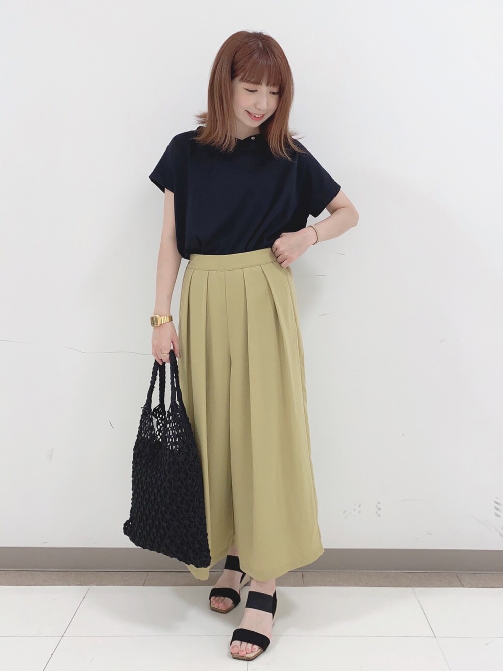 ブラック系のTシャツ/カットソー、イエロー系のその他パンツ、ブラック系のサンダルを着用したレディースの春コーディネートの4枚目の写真
